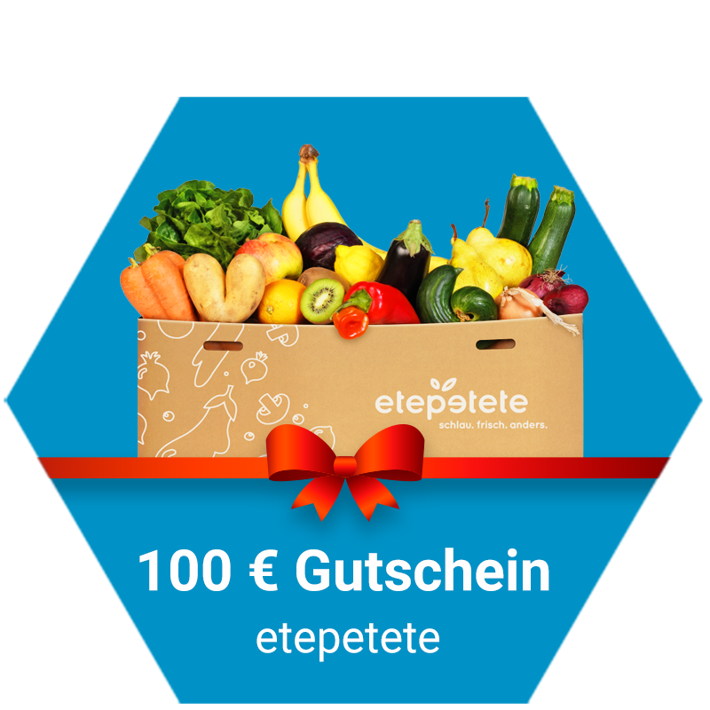 Geschenkgutschein von etepetete im Wert von 100 Euro: Eine Kiste mit buntem Obst und Gemüse, dekoriert mit einer roten Schleife, auf blauem Hintergrund.